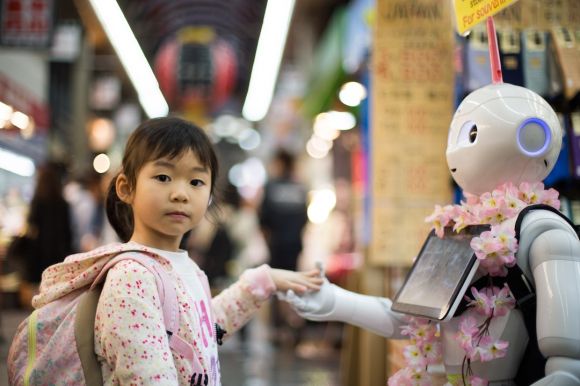 Robot - photo of girl laying left hand on white digital robot