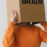 Human Brain - Crop person putting Idea title in cardboard box with Brain inscription on head of female on light background
