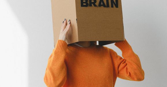 Human Brain - Crop person putting Idea title in cardboard box with Brain inscription on head of female on light background